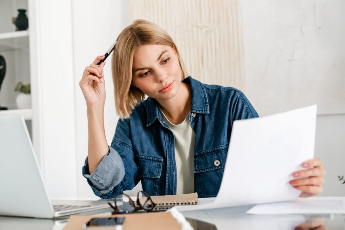 A tenant holding a pen to her head
