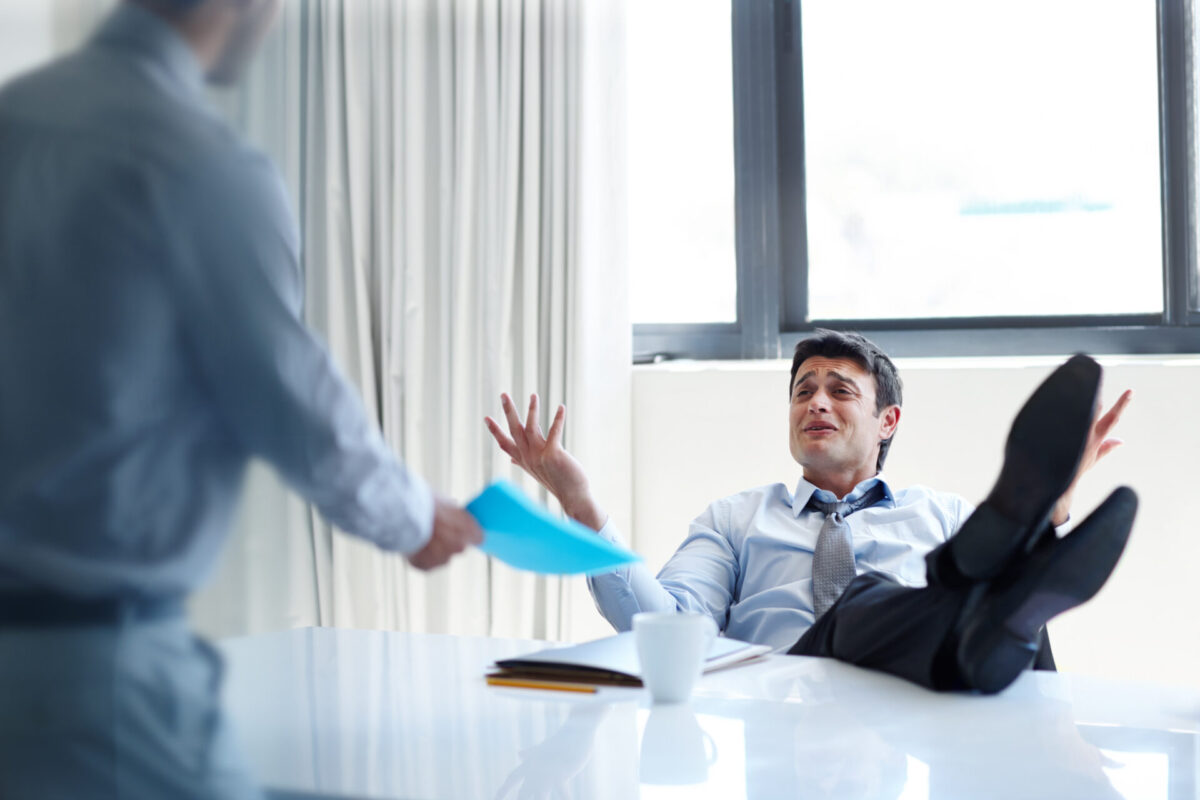 Lazy, businessman and relax with argument in office for meeting, negligence or lack of productivity. real estate agent and feet on desk with poor work ethic